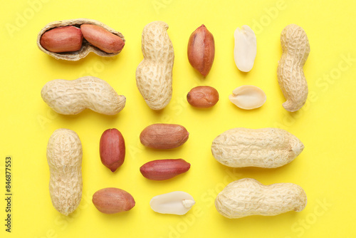 Fresh peanuts on yellow background, flat lay