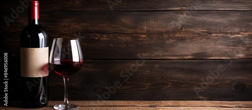 Detailed view of a wine bottle and a glass of wine on a wooden background. with copy space image. Place for adding text or design
