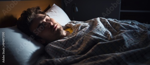 Young man deeply sleeping in bed, snoring while covered with a blanket and resting on a pillow. with copy space image. Place for adding text or design