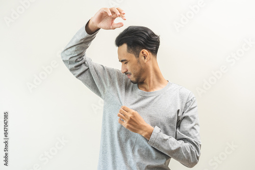 Bad smelling, deodorant asian young man smell stink, breathing nose smelly on shirt dirty stinky laundry, disgusting from clothes after washed, smelly armpit underarm Medical health, skin body care.