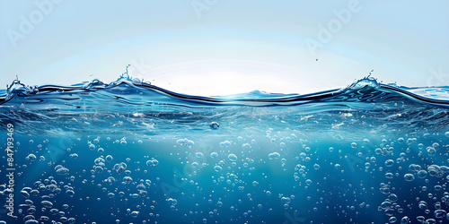 Blue water with air bubbles and clear sky, cross-section of deep ocean with waves on the surface, rays of light illuminating clear dark blue water, marine landscape, copy space, with copy space