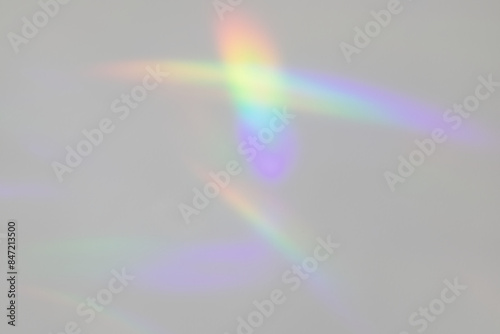 A photograph of abstract rainbow light patterns cast on a plain background.