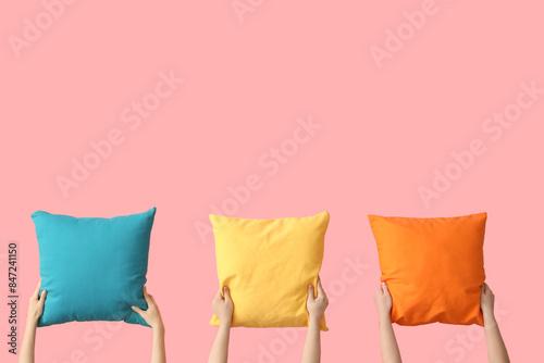 Women with bright pillows on pink background