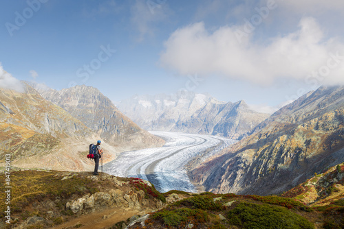 Automnal landscape view of a hiker contemplating the Aletsch glacier