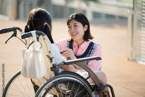 車椅子に乗る子供と介護や補助をする介護士や看護師 上半身 ホームヘルパーやデイサービスのイメージ