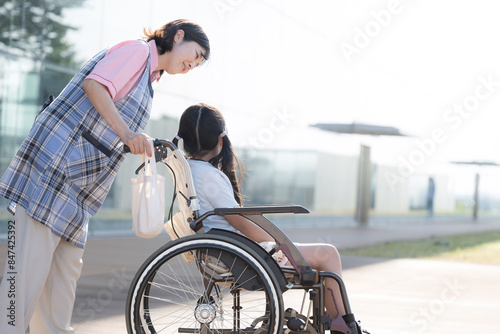 車椅子に乗る子供と介護や補助をする介護士や看護師 ホームヘルパーやデイサービスのイメージの全身
