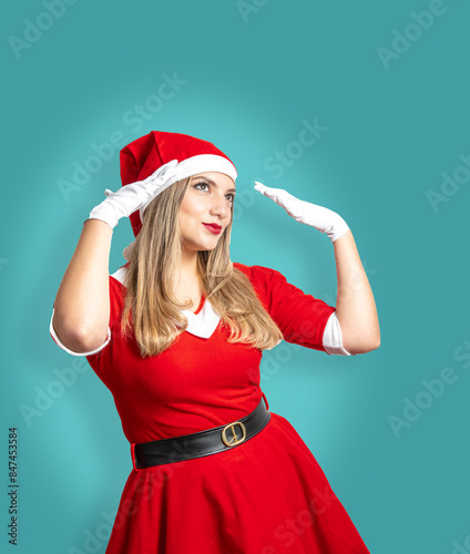 Young blonde woman dressed as Mama Noel with a flirtatious look on a turquoise background