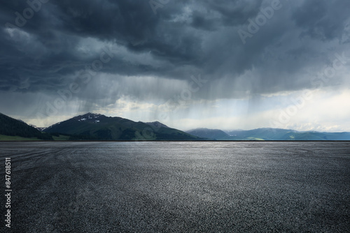 Asphalt road square and mountain with black rain clouds natural landscape before the rainstorm