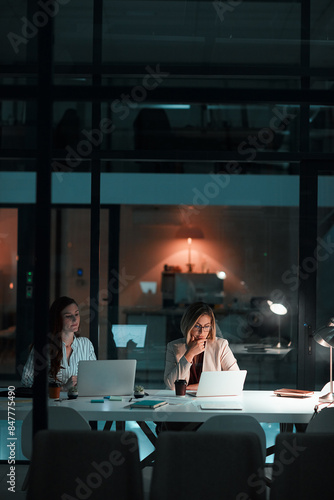 Employee, women and laptop in office at night with documents for deadline or overtime as accountant. Business, partner and data capture for financial reviews, records and auditing in company report