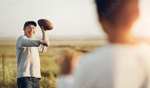 Kid, dad and throw with football on grass field for outdoor sports, exercise and child development. Smile, man and happy with son in nature for teaching, practice and bonding together on fathers day