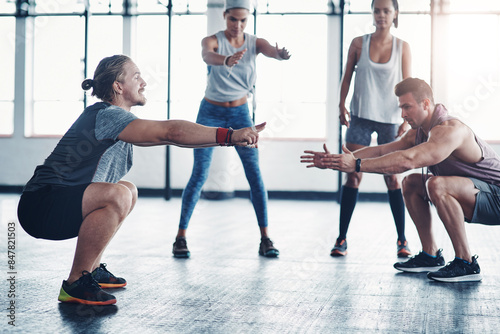 People, gym and squat exercise for fitness in health club, wellness workout and strength for muscles or group. Challenge, body and balance or stability for core training, determination and instructor