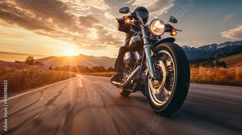 A motorcyclist rides on a scenic highway at sunset, capturing the spirit of adventure and freedom on the open road.