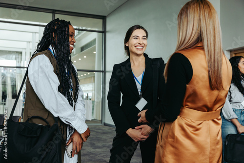 Networking businesswomen smiling and talking at professional conference