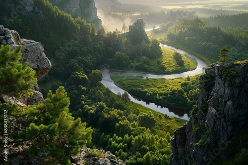 Capturing the beauty of a winding river as it meanders through a lush green valley, framed by towering trees and rocky cliffs 