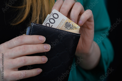 Kobieta wyciąga pieniądze z portfela, z bliska