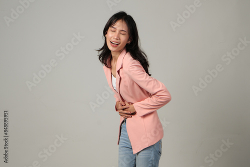 Asian woman unhappy looking sick, suffers from stomach ache stomachache on isolated background. because of menstruation and eating spoiled food, Chronic gastritis. Abdomen bloating concept