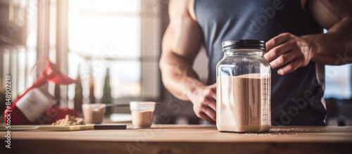 Man preparing protein shake concept of sports fitness healthy lifestyle with close up copy space image of jar and bottle