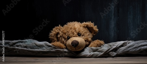 Teddy bear with eyes covered in an empty room front view copy space image available