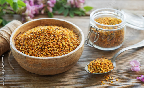 Healthy bee pollen grains. Bee pollen on a bowl and acacia flowers.