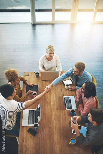 Business people, handshake and meeting with team above for thank you, greeting or agreement at office. Top view of group or employees shaking hands in deal, collaboration or introduction at workplace