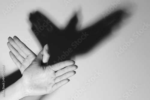 Woman making hand gesture like bird on light background, closeup with space for text. Black and white effect