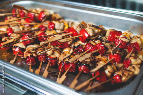 Beautifully decorated catering banquet table with different main course hot food dishes and garnish, with rice, chicken, salmon fish, lamb, vegetables and kebab on party event wedding celebration