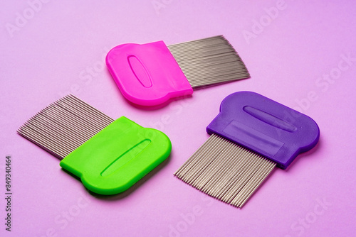 Three combs for removing lice and nits on lilac background