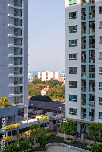 Tall light buildings with windows and small balconies in a city on the sea coast. Construction and real estate.