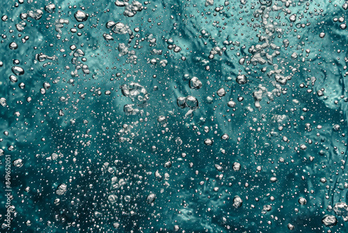Abstract image of air bubbles rising in clear, teal water