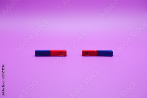 two bar magnets isolated on a purple background