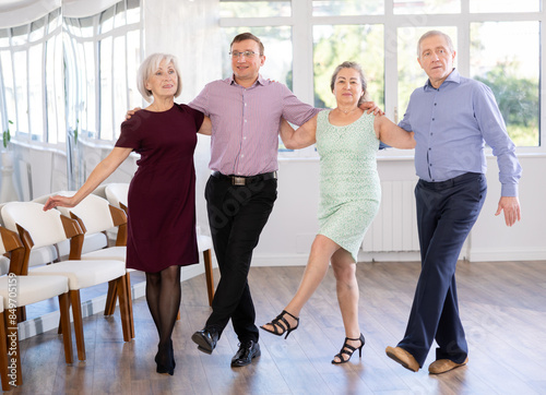 Elderly people with middle-aged man holding hands dancing hava nagila. Dance lessons for amateurs and beginners