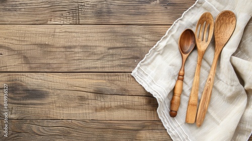 Wooden table napkin and kitchen utensils on a natural wood background with empty space