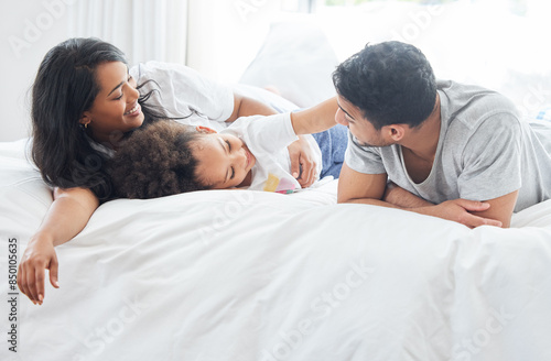 Child, parents and family in bed for morning with love relationship, parent support and bonding together in home. Mother, father and young girl in bedroom for wake up with lazy weekend and relax