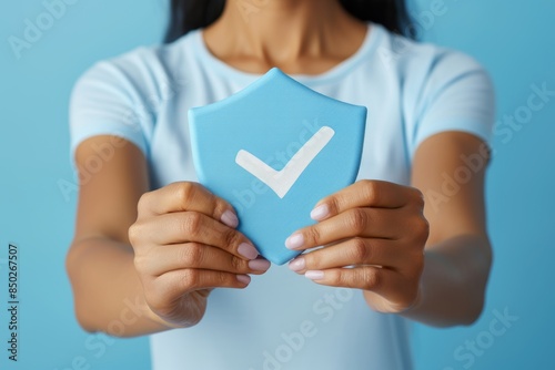 Hands holding a blue shield with a checkmark, representing security, protection, and trust in a safe and reliable concept, Generative AI