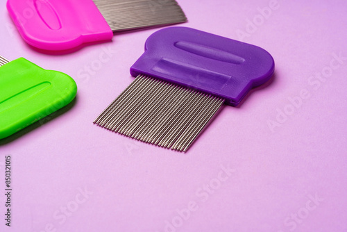 Three combs for removing lice and nits on lilac background