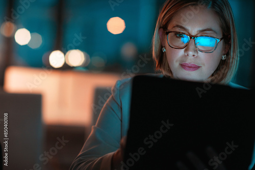 Corporate woman, tablet and reading at night in office for company agenda, research and planning. Digital, tech and working email or report for business results, growth and revenue with deadline