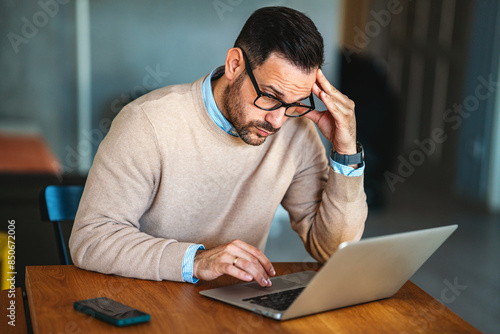 Thoughtful doubtful businessman in tension thinking make difficult decision at work, stressed man