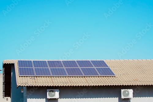 Solar energy plate on the roof of the house and two air conditioning units