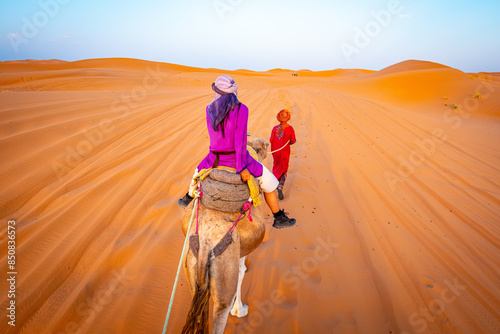 Camel ride, desert tour in Merzouga, Morocco, Erg Chebbi dunes and path for camping in the Sahara. Sunrises and sunsets to overnight destination in Berber desert camp