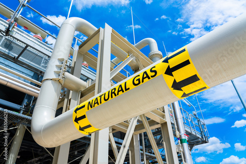 Natural gas pipeline with high pressure and direction sign at compressor station. Concept of energy transportation infrastructure