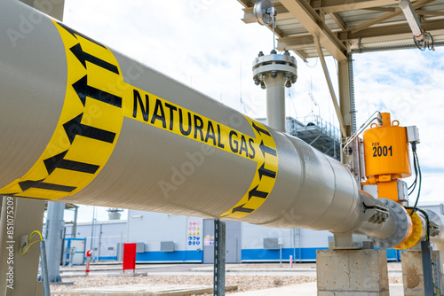 High pressure natural gas pipeline with direction sign at compressor station. Concept of energy supply and safety