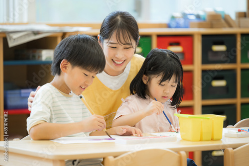 学童や放課後デイサービス等で勉強をする先生と生徒 小学生複数と見守る先生