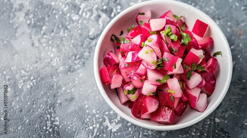 Chopped ripe red radishes in a white bowl. 