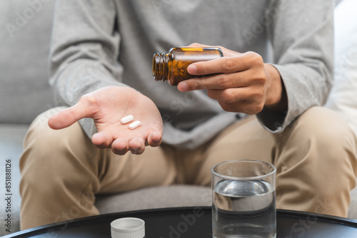 Close-up a medicine tablet in young man hand taking painkiller