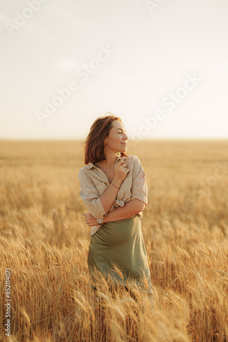 A tranquil scene of a young woman embracing herself, standing amidst a golden wheat field at sunset, conveying a sense of peace and self-love.