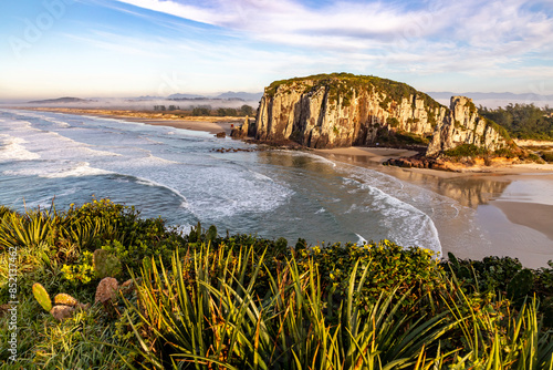 Guarita beach with waves, cliffs and winter fog over the trees