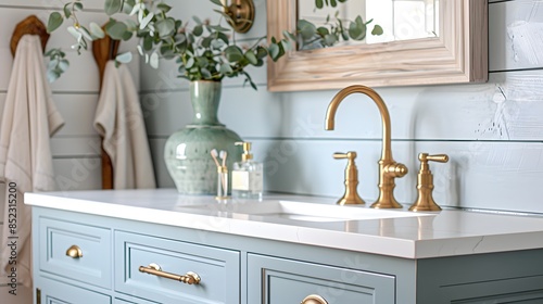 Bathroom vanity with light blue cabinets and white countertop, farmhouse style, golden hardware, pale green ceramic sink bowl, brass faucet and spigot, shiplap wall in the background,