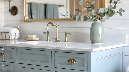 Bathroom vanity with light blue cabinets and white countertop, farmhouse style, golden hardware, pale green ceramic sink bowl, brass faucet and spigot, shiplap wall in the background,