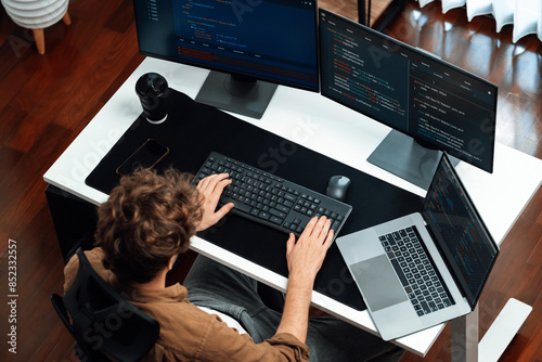 IT developer working online software development on pc monitors on top view at modern home office on coding application screens, creating updated program firmware information version concept. Gusher.