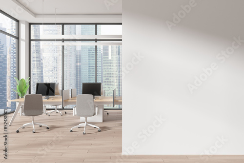 Office coworking interior with pc desktops on tables, window. Mockup wall